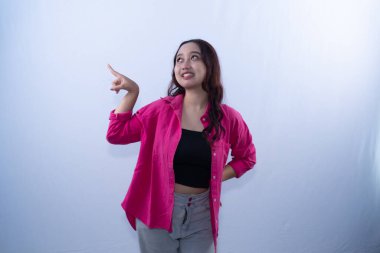 Pembe gömlekli ve gri pantolonlu gülümseyen genç bir kadın yukarı bakıyor.