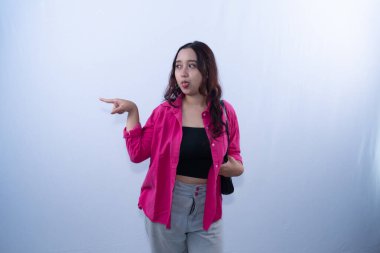 Pembe tişörtlü genç bir kadın şakacı bir ifadeyle yana bakıyor.