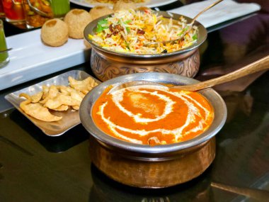 Yakın plan tereyağlı tavuk, Hint restoranındaki süslü bir tencerede. Lezzetli geleneksel Hint yemekleri..