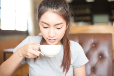 genç ve güzel Asyalı kadın, Odaya yumuşak kahve içme ve seçileceği yer