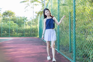 Tenis kortunda Tenis oynadıktan sonra güzel Asyalı kız