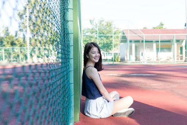 Hermosa chica asiática en pista de tenis después de jugar tenis —  Fotos de Stock