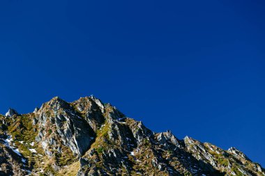 Romanya 'nın Fagaras Dağları' ndaki derin mavi gökyüzünün altındaki kayalık dağlar. Transfagarasan otobanından görüntü. Boşluğu kopyala.