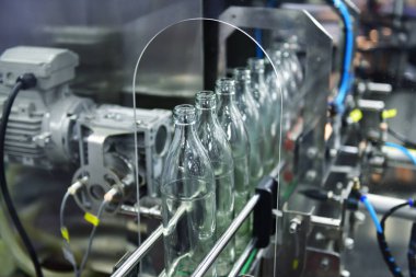 Modern şişeleme fabrikasında boş cam şişelerle taşıma bandı.