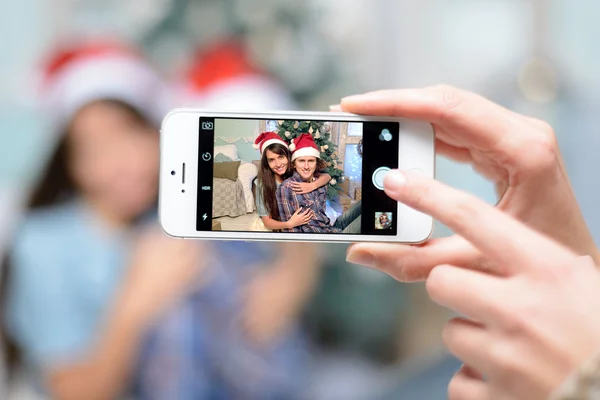 Ludzie, mężczyzna i kobieta, robienie zdjęć, ich zdjęcia na telefon w tle, w pobliżu, choinkowe, christmas party, szczęśliwy nowy rok 2016 — Zdjęcie stockowe