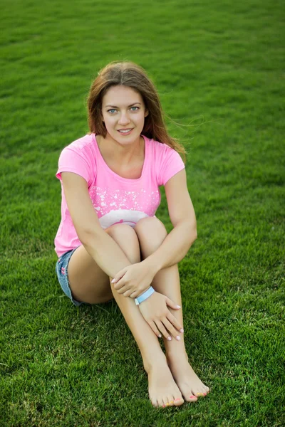 Bir kız çimlerde oturuyor