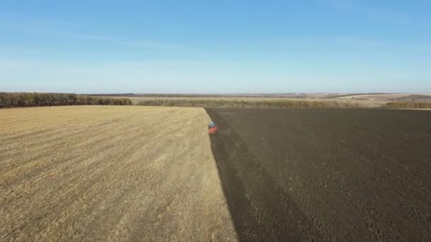 Antenna: traktorok a szántás a területen, őszi naplemente. — Stock videók