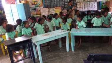 Devlet okulu üniformalı, sınıfta kitapla çalışan kimliği belirsiz sınıf arkadaşları. Şirin, tapılası yüzler.