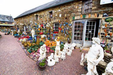 NORON LA POTERIE, FRANCE - Ağustos Circa, 2020. Dükkanda çok fazla çömlek var. Farklı formlar, hayvanlar, dekore edilecek renkler, bahçe. Ana tipler arasında toprak eşyalar ve taş yazılımlar yer almaktadır.