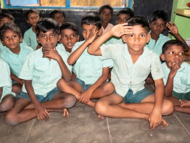 PUDUCHERRY, İNDİA - Aralık 2019. Tanımlanamayan mutlu öğrenciler devlet okulu üniformalı sınıf arkadaşları evde oturup ders çalışıyorlar. Yardım için gülümseyen zavallı çocukların portresi.