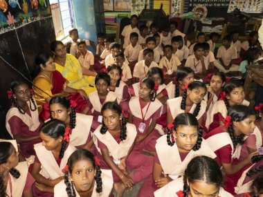 PUDUCHERRY, İNDİA - Aralık 2019. Tanımlanamayan mutlu öğrenciler devlet okulu üniformalı sınıf arkadaşları evde oturup ders çalışıyorlar. Yardım için gülümseyen zavallı çocukların portresi.