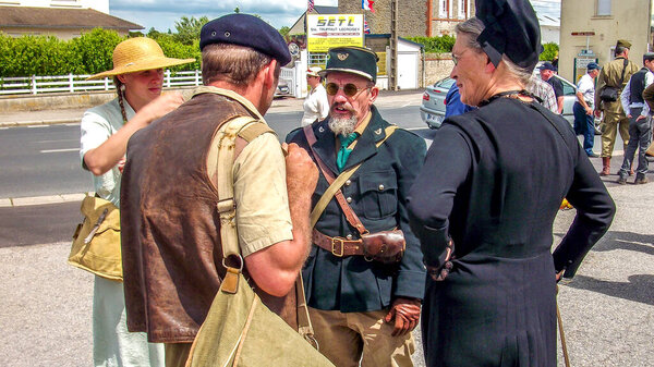 SAINTE MERE L'EGLISE, FRANCE - JUNE 6, 2019. Parade of People dressed up in 1940's clothing posing in front of a World War 2, D-Day ceremony in Normandy. People found liberty after 5 years war. Happy day memorial