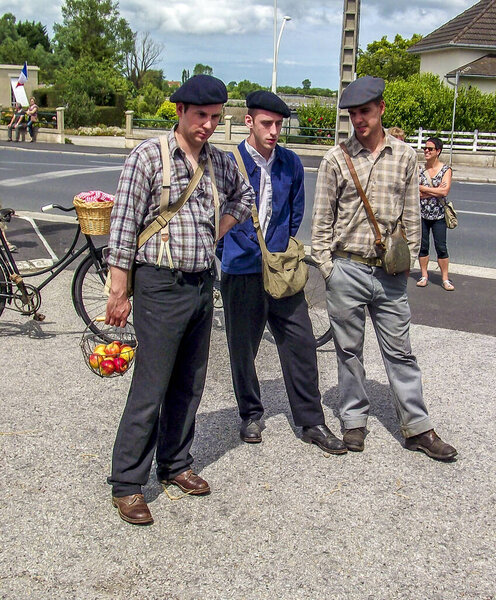 SAINTE MERE L'EGLISE, FRANCE - JUNE 6, 2019. Parade of People dressed up in 1940's clothing posing in front of a World War 2, D-Day ceremony in Normandy. People found liberty after 5 years war. Happy day memorial