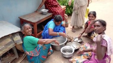 PUDUCHERRY, İNDİA - Aralık 2019. Kimliği belirsiz bir grup Hintli Harijan 'lı kadın sokak köyünde yerde oturuyor ve balık almak için balık seçiyorlar. Birlikte konuşuyoruz..