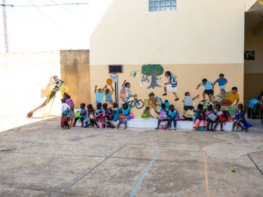 Bour, Senegal - 2021 Temyiz Dairesi. Üniformalı, kimliği belirsiz, siyah, şirin çocuklar ilkokulda bir bankta oturuyorlar. Dinlenme sırasında kahvaltı yapmak..