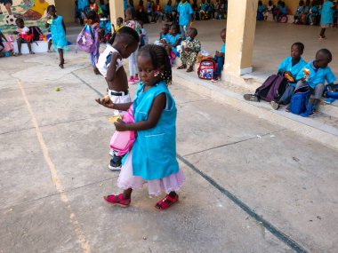 Bour, Senegal - 2021 Temyiz Dairesi. Üniformalı, kimliği belirsiz, siyah, şirin çocuklar ilkokulda bir bankta oturuyorlar. Dinlenme sırasında kahvaltı yapmak..