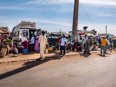 Bour, Senegal - Aralık 2021 civarı. Corona Virüsü maskeli birkaç kadın ve erkek köy pazarında yürüyor. Bazıları maske takıyor, bazıları takmıyor. Senegal halkı covid 19 'un gerçekliğini reddediyor..
