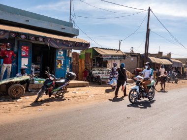 Bour, Senegal - Aralık 2021 civarı. Corona Virüsü maskeli birkaç kadın ve erkek sokak köyünde yürüyor. Bazıları maske takıyor, bazıları takmıyor. Senegal halkı covid 19 'un gerçekliğini reddediyor..