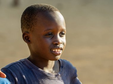 Bour, Senegal - 2021 Temyiz Dairesi. Tanımlanamayan genç Senegalli çocuğun portresi, kameraya bakıyor. Güzel cilt, saçlar, açık renk. Mutlu bir duygu. Açık havada.