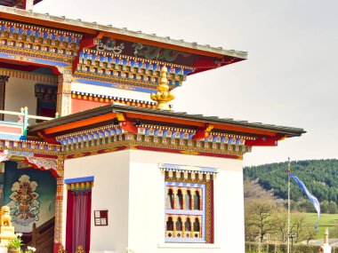 LA BOULAYE, FRANCE - Nisan 2018. Bin Budha tapınağının çatısının renkli detayları. Tahta oyma. Farklı boyutlarda Buda heykelleri, birçok Thangka tabloları, duvar freskleri ve Frie heykelleriyle çok renkli, üç katlı Bhutanese tarzı.