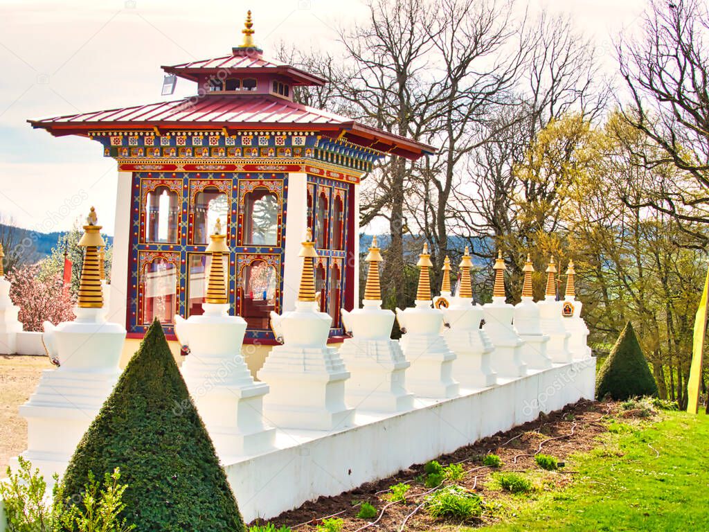 LA BOULAYE, FRANCE - APRIL Circa, 2018. Large outdoor view of the famous One thousand buddhas temple. It is multicolored, three-tiered Bhutanese style with statues of Buddhas of various sizes, many Thangka paintings, wall frescoes and friezes