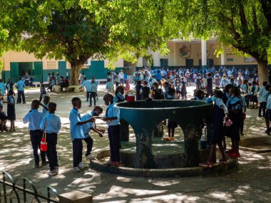 Bour, Senegal - 2021 Temyiz Dairesi. İlk sınıftaki kimliği belirsiz bir grup genç kız ve erkek çocuk teneffüs sırasında okul bahçesinde maske takıyor. Sosyal mesafeye saygı yok.