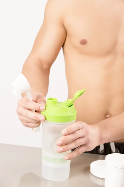 Protein shake şişeyle atletik güzel adam — Stok fotoğraf