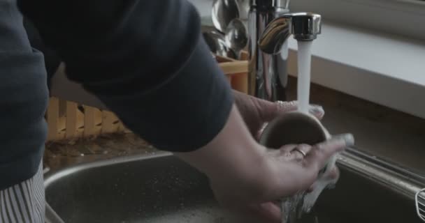 Женщина моет посуду в раковине — стоковое видео