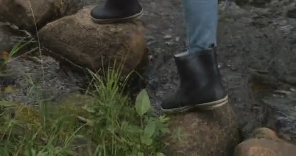 Meisje gaat op de rotsen in de buurt van de rivier — Stockvideo