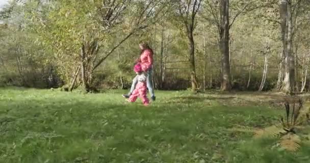 Glückliche junge Mutter mit ihrer Tochter im Park mit Telefon — Stockvideo