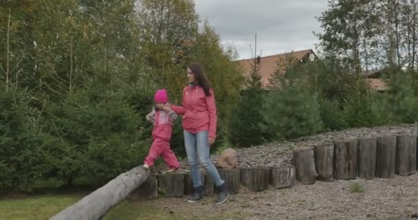 Ευτυχισμένος νεαρή μητέρα με την κόρη της σε εξωτερικούς χώρους σε πάρκο — Αρχείο Βίντεο