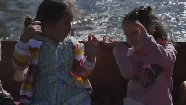 Две маленькие девочки с родителями в туристической лодке вдоль рек — стоковое видео