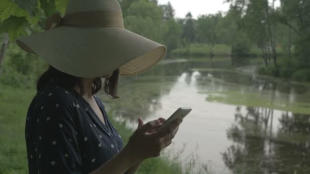 A lány a parkban, a telefon — Stock videók