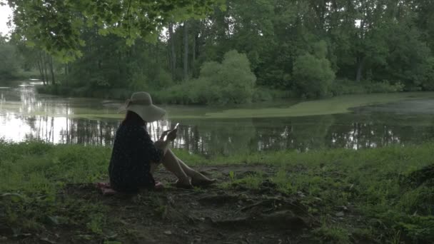 Das Mädchen im Park mit dem Handy — Stockvideo