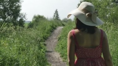 Yol boyunca, fps96 şapka ve uzun elbise genç kız gelir