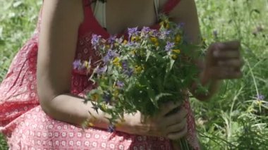 çiçek autiful kadınla çimenlerin üzerinde bir parkta oturuyor