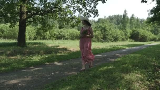 The girl in the Park and holding a bouquet of flowers and smiling — Stock Video