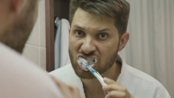 Hombre cepillándose los dientes por la mañana — Vídeo de stock