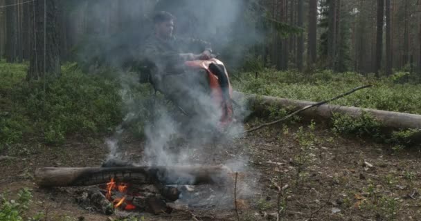 Muž sedí u táboráku — Stock video