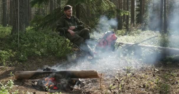 Ένας άνθρωπος που κάθεται σε μια campfire — Αρχείο Βίντεο