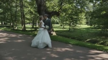 Yeni evli çift el ele parkta yürüyüş