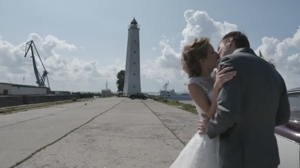 Jovem casal feliz beijando ao pôr do sol dourado.Jovem casal feliz recém-casado desfrutando do oceano durante as férias de viagem . — Vídeo de Stock