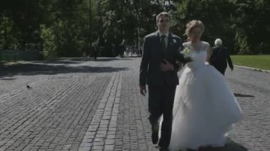 Yeni evli çift el ele parkta yürüyüş