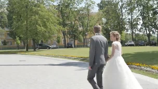 Una pareja de recién casados caminar en el parque — Vídeos de Stock