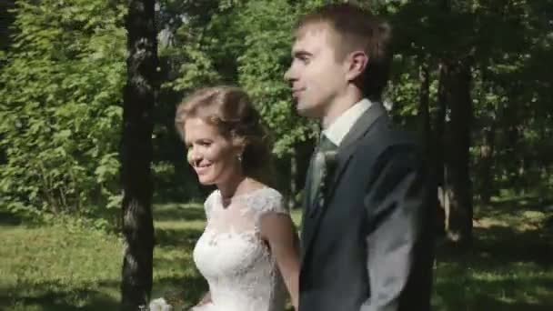 Couple nouvellement marié marchant dans le parc 