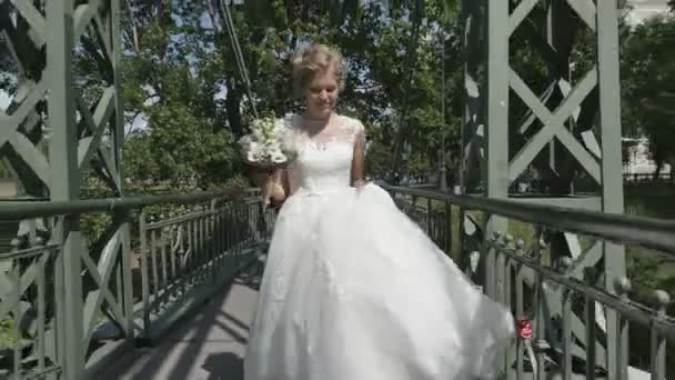 Jonge gelukkige bruid glimlachend bedrijf boeket van rode bloemen. Middellange schot — Stockvideo