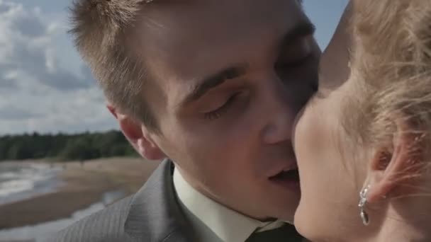 Mariés s'embrassant sur la plage, gros plan, caméra de mouvement 