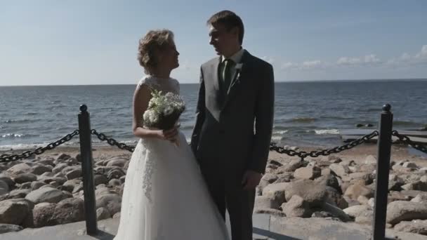 Het echtpaar op het strand na de bruiloft, romantische bruid en bruidegom — Stockvideo