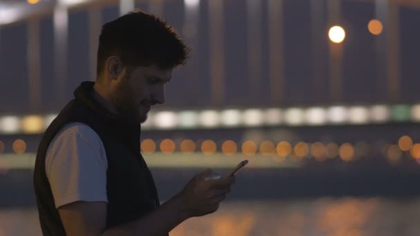 Giovane con telefono guardando il ponte di Perth, il grande fiume Neva — Video Stock