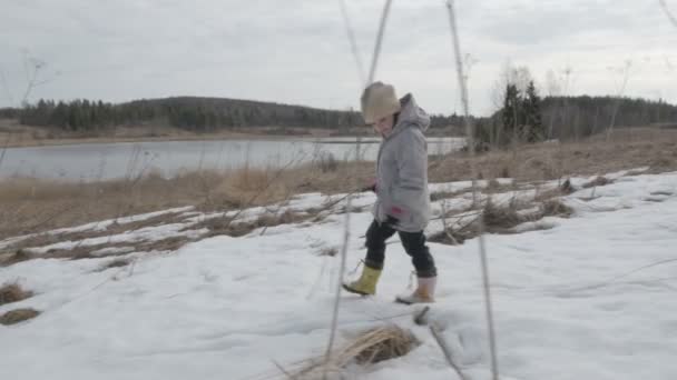Маленькая девочка ходит по полю весенний пейзаж — стоковое видео
